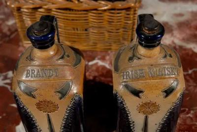 Two Victorian English Pottery Decanters in Tantalus Inspired Wicker Basket