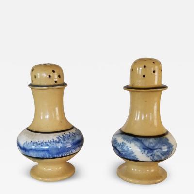 Two yellowware pepper pots each with heavy dark blue seaweed