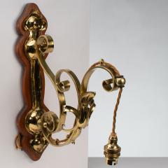 A Set of Three Arts Crafts Brass Wall Lights with Walnut Backplates - 4192507