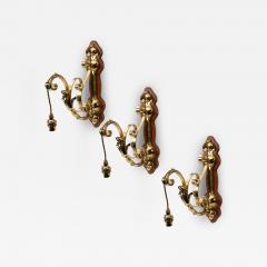 A Set of Three Arts Crafts Brass Wall Lights with Walnut Backplates - 4234372