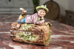 French 19th Century Barbotine Bonbon Box Depicting a Boy Laying on a Tree Trunk - 3424128