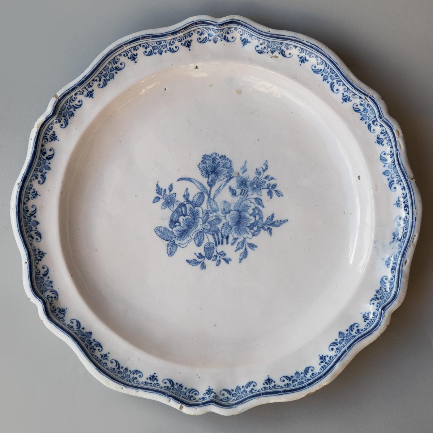 18TH CENTURY MOUSTIERS PLATE WITH A SCALLOPED RIM